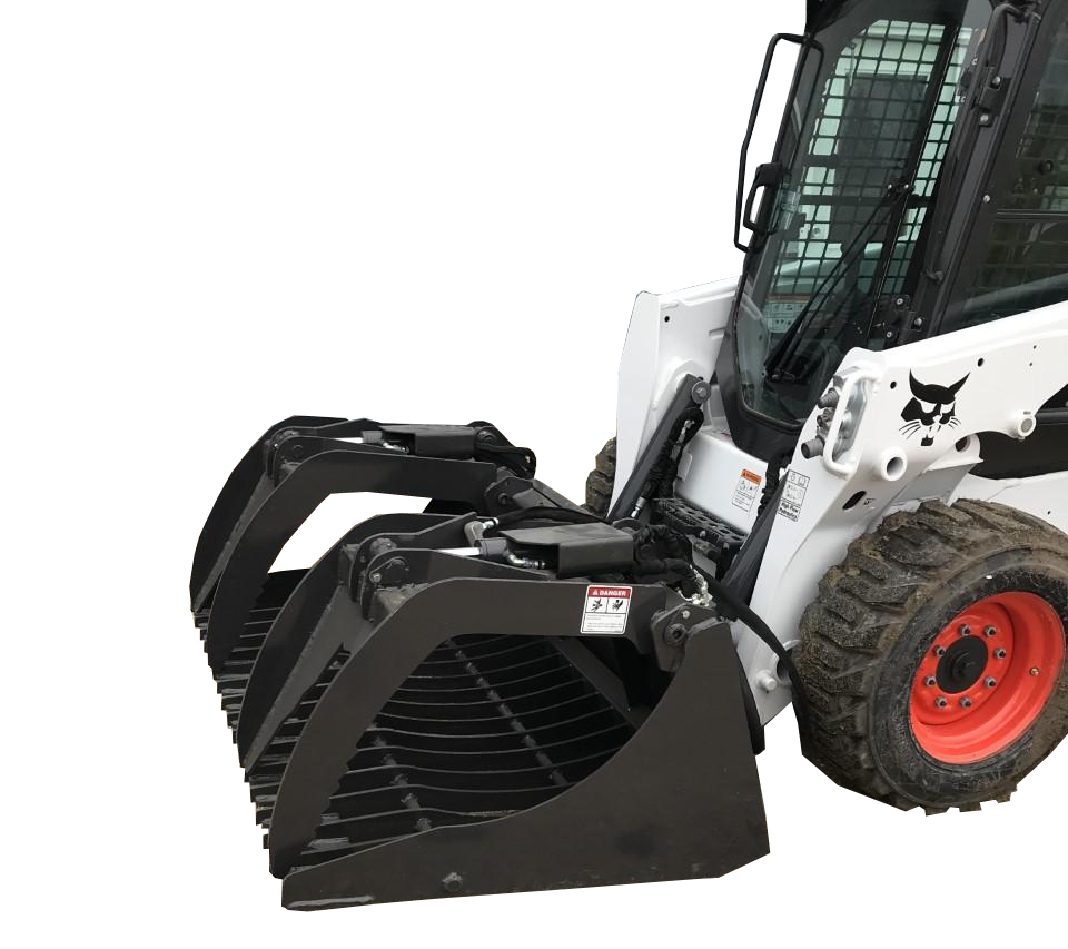 A close-up view of a skid-steer loader, equipped with the Skid-Steer Rock Grapple Bucket, sits parked on a gravel surface near a building.