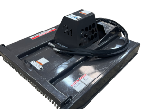 The Dingo Brush Cutter is a black, industrial-grade attachment with hydraulic hoses, metal housing, and warning labels, specifically designed for use with Dingo construction equipment.